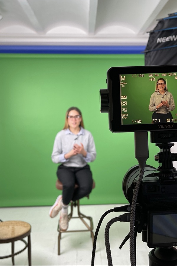 Victoria grabando contenido en un estudio con pantalla verde